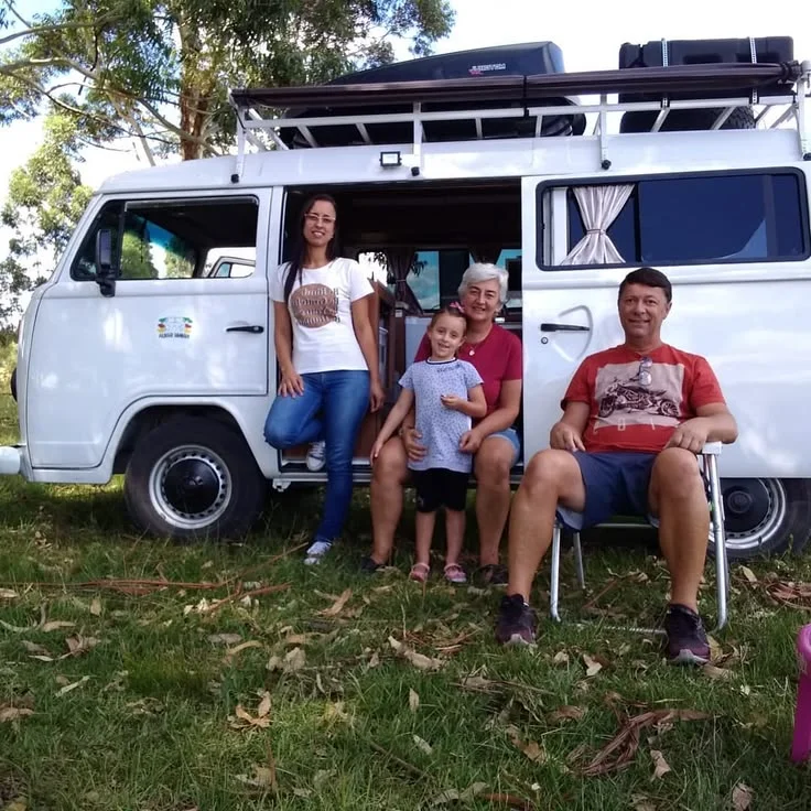 Eduardo, Niaia, a filha e a neta reunidos junto à Kombi